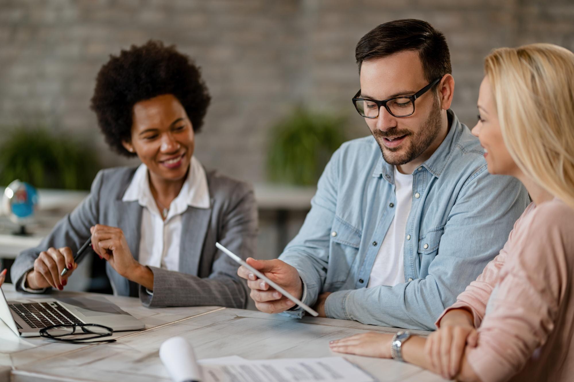 Financial advisor reviewing documents with clients at a meeting table