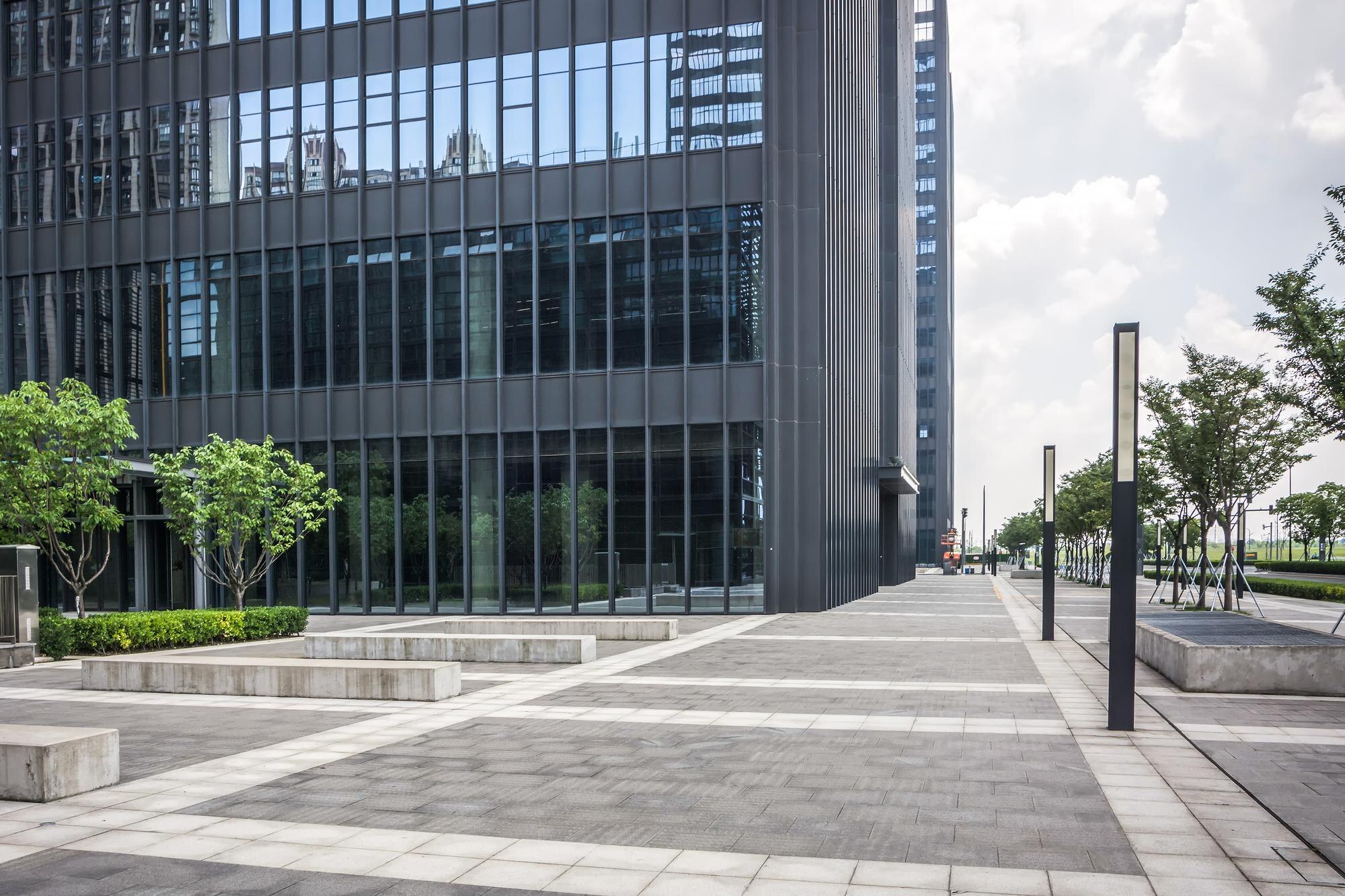 Modern office building exterior with trees and walkway